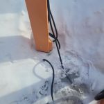 EV charger with cord stuck in the snow